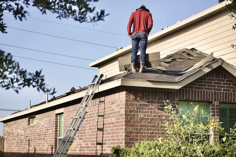 Professional roofer working on a residential roof in Manville